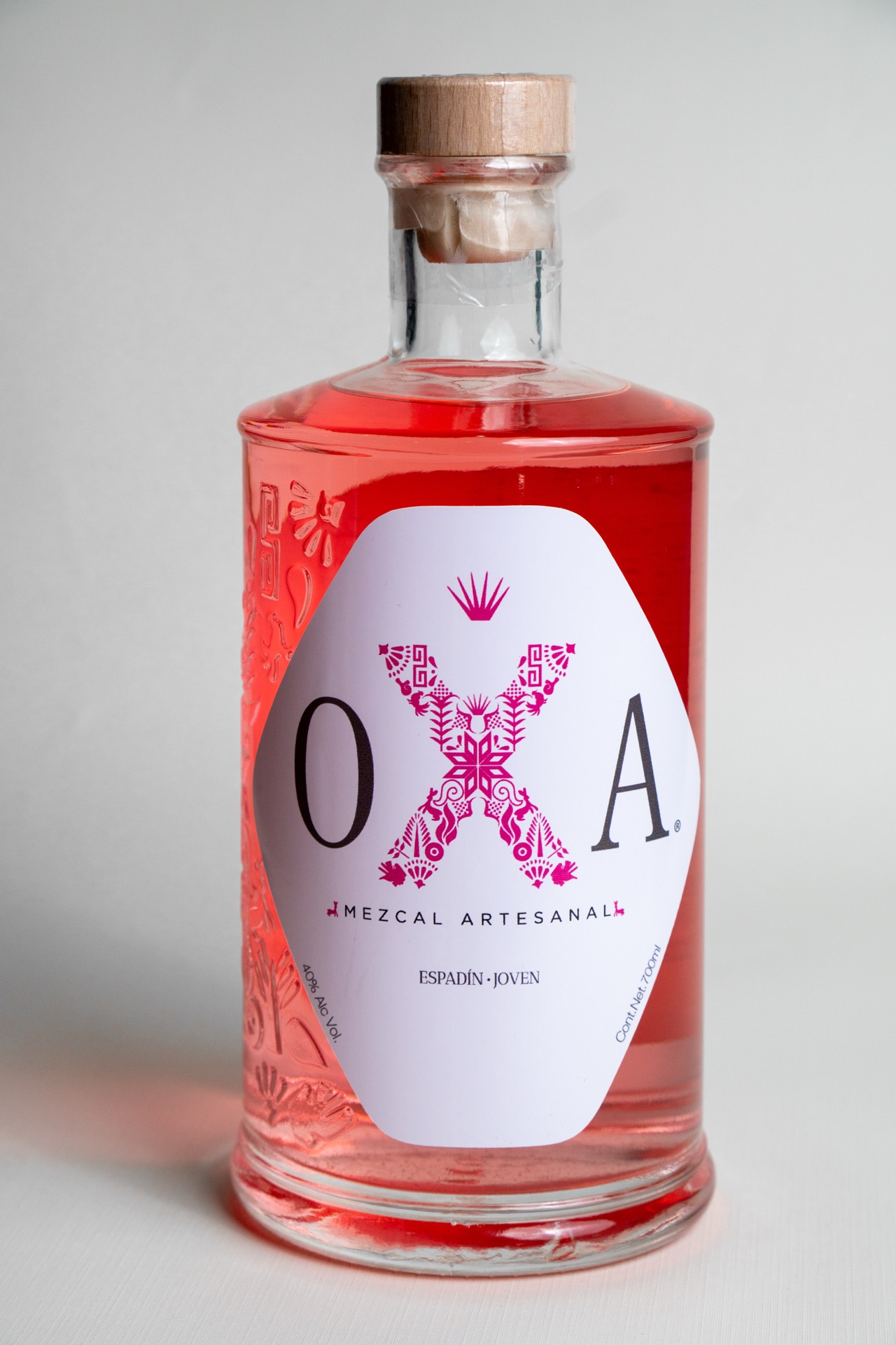 Botella de OXA Rosa, de color rosa natural de grana cochinilla, sobre fondo claro.